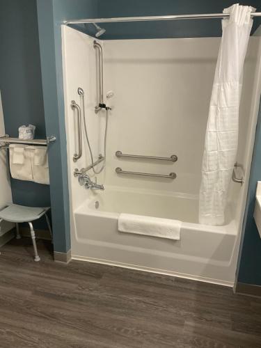 迈尔斯堡WoodSpring Suites Fort Myers - Cape Coral的带淋浴、毛巾和盥洗盆的浴室