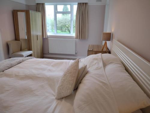 埃姆斯伯里罗宾山别墅的卧室内的一张大白色床,带有窗户