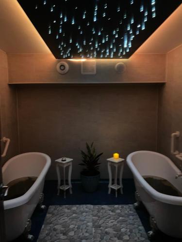 BallydavidThe Coastguard House @ Tigh T.P.的浴室设有两个浴缸和天花板上的灯。