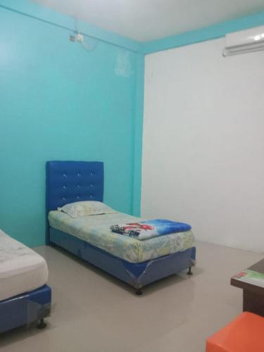 Dukupenginapan alleo的一间设有一张蓝色墙壁的床的房间