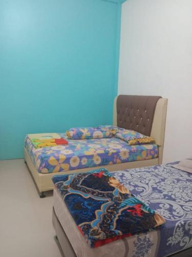 Dukupenginapan alleo的一间设有三张床和蓝色墙壁的房间