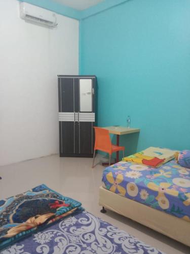 Dukupenginapan alleo的一间卧室配有两张床、一张桌子和一台冰箱