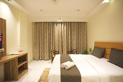 新德里Hotel GOOD LUCK HOUSE Near Delhi Airport的酒店客房设有一张大床和一张书桌。