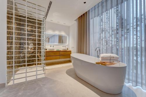 吉亚德伊索拉Green House - Modern Villa in Tenerife, Spain的带浴缸的浴室和大窗户