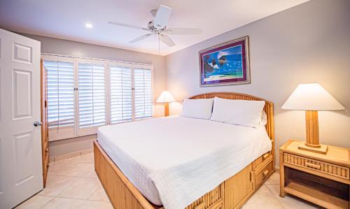 西湾七里滩公寓式酒店的一间卧室配有一张床和吊扇