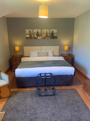 百利科内尔当杰名酒店的一间卧室配有一张大床,墙上有两张照片
