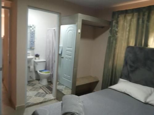 博卡奇卡Villa rozenuda的浴室设有床、卫生间和镜子