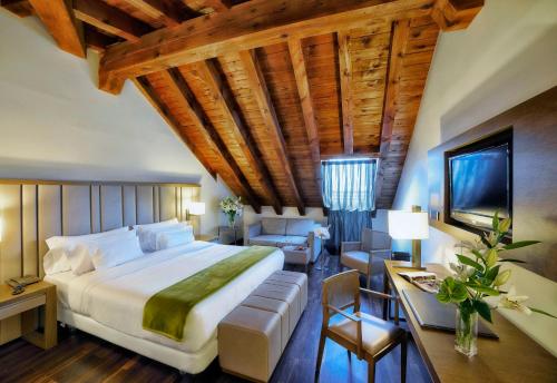 马德里帕拉西奥特帕NH精选酒店的一间带大床的卧室和一间客厅
