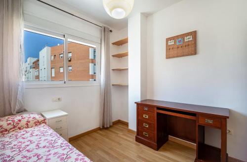 圣费尔南多Sensacional piso en San Fernando的一间卧室配有一张床、一张书桌和一个窗户。