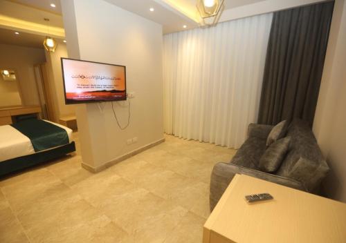 阿莱曼Coast Hotel的一间客厅,客厅配有沙发和电视,位于酒店的房间