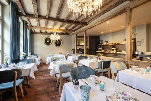 布鲁日Hotel Biskajer by CW Hotel Collection - Adults Only的餐厅配有白色的桌椅和吊灯