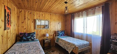 圣地亚哥太阳和月亮旅舍的小木屋内一间卧室,配有两张床