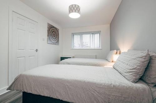 利物浦Park & Relax in 1bd Central Liverpool home的一间白色卧室,配有两张床和窗户