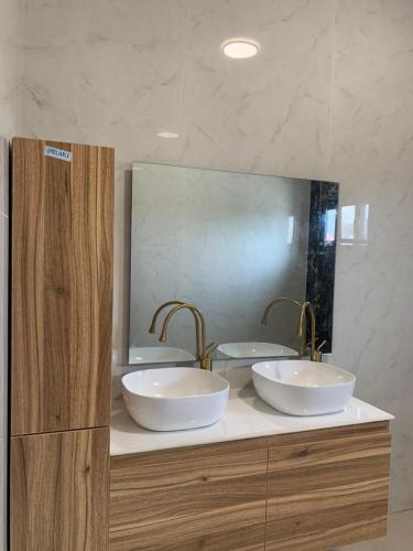 科托努Luxe Dandji的一间带两个盥洗盆和大镜子的浴室