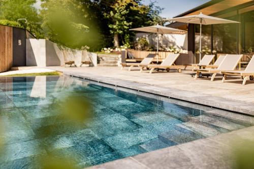 崔聂斯陶伯斯生态城堡酒店的一个带躺椅和遮阳伞的游泳池