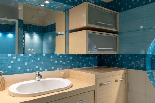 克拉科夫Kraków Główny Apartment - Parking, Workspace - by Rentujemy的浴室配有水槽和蓝色瓷砖墙壁。