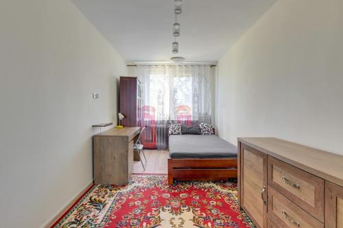格但斯克Summer 2 by Grand Apartments的一间卧室配有一张床、一张桌子和一张地毯。