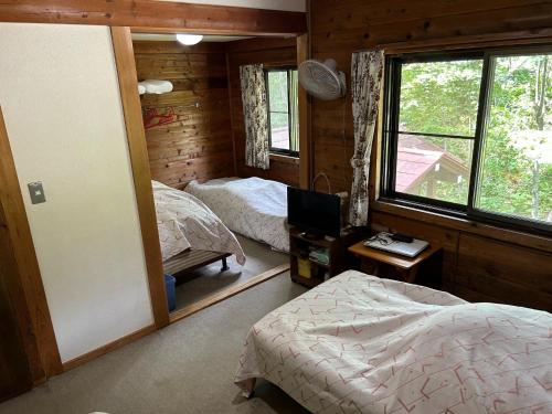 上山市Zao Pension Aramiya - Vacation STAY 40314v的一间卧室设有两张床和窗户。