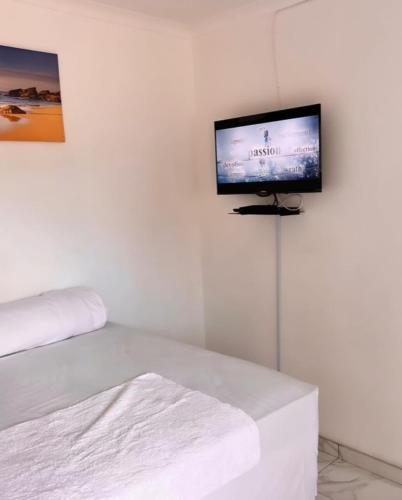 温特和克Comfort Guesthouse的一间白色墙壁上配有平面电视的房间