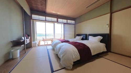 伊喜末HOTEL GREEN PLAZA SHODOSHIMA - Vacation STAY 46464v的一间卧室设有一张大床和大窗户