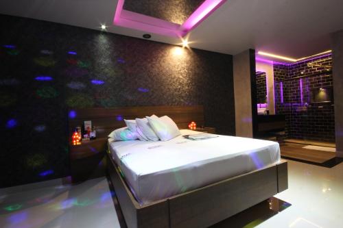 里梅拉Motel Deslize Limeira 2的紫色灯室里一间卧室,配有一张床