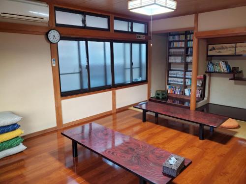 京丹后市Kotohi - Vacation STAY 16047的客厅设有两张桌子和墙上的时钟