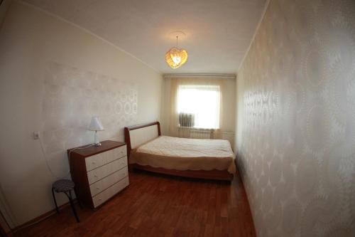 赤塔Dekabrist apartment at petrovsko-zavodskaya 31的一间卧室配有一张床、一个梳妆台和一扇窗户。
