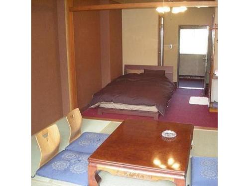 上川Houraku - Vacation STAY 23215v的卧室配有一张床和一张桌子及椅子