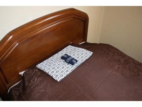 函馆Hotel Tetora Yunokawaonsen - Vacation STAY 30586v的一张带木头床头板的床,上面有枕头