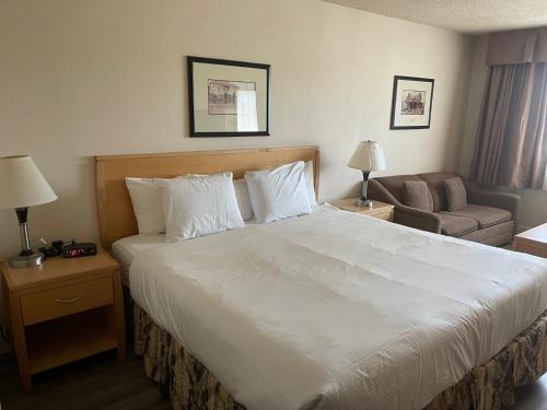 高贵林Chelsea Inn的酒店客房设有一张大床和一张沙发。