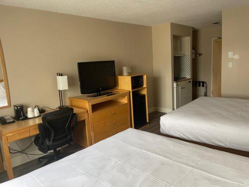 高贵林Chelsea Inn的酒店客房配有一张床和一张书桌及一台电视