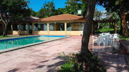 萨尔瓦特拉Hotel e Pousada Marajó的一座带游泳池和桌椅的房子