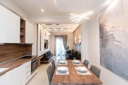 塞萨洛尼基Tsimiski's Pearl的厨房以及带木桌和椅子的客厅。