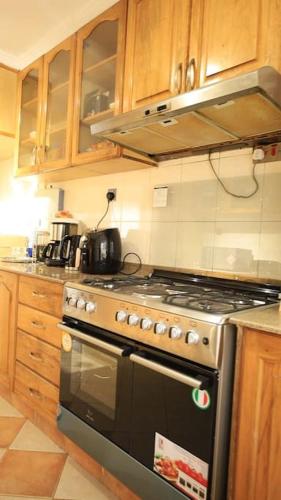 内罗毕U4RIC Villa-3bed house in Kileleshwa gated community的厨房配有不锈钢炉灶和木柜。