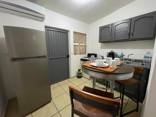 埃莫西约Cozy studio apartment located in commercial area的厨房配有小桌子和冰箱。