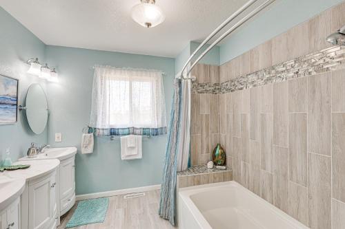 拉皮德城Scenic and Serene Rapid City Getaway on 1 half Acres!的浴室配有蓝色的墙壁、浴缸和水槽。
