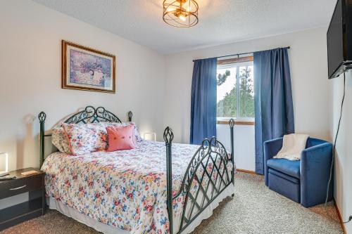 拉皮德城Scenic and Serene Rapid City Getaway on 1 half Acres!的一间卧室配有一张床、一把蓝椅和一个窗户。