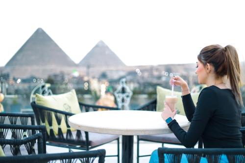开罗The Muse Pyramids INN的坐在桌边喝一杯的女人