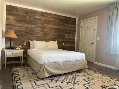 Mexican HatMexican Hat Lodge的一间卧室设有一张床和木墙