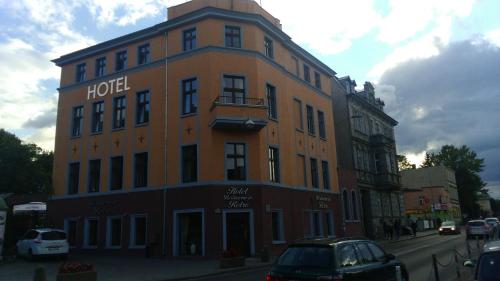 绿山城Hotel Retro B.A. Zientarski的一座大型橙色建筑,街道上有一家酒店