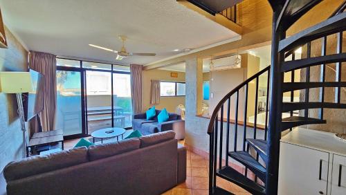 卡尔巴里Riverview Holiday Apartment 13 - Kalbarri, WA的带沙发和楼梯间的客厅