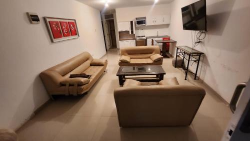 卢林Departamentos en Playa Pulpos HOSPEDAJE DELFINES HOUSE的带沙发、桌子和电视的客厅
