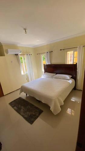 拉纳韦贝Serenity Escape的一间卧室设有一张床和两个窗户。