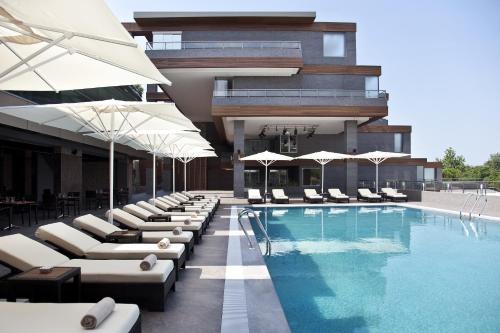 伯萨迪万布尔萨酒店的酒店设有带躺椅和遮阳伞的游泳池