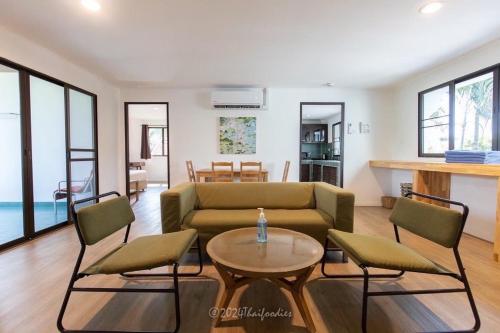 三百岭Dolphin Bay Beach Resort的客厅配有沙发、椅子和桌子
