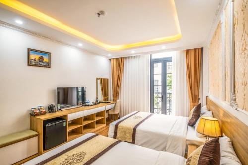 下龙湾Thành Đô Hotel Hạ Long的酒店客房设有两张床和电视。