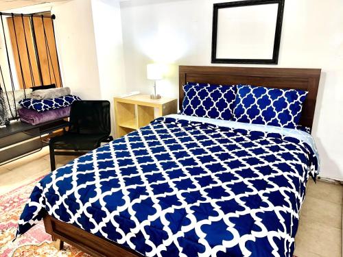 长岛市Manhattan in 2 stopages, 2 Bedrooms Apt with private Backyard in LIC !!!的卧室配有蓝色和白色的床和椅子