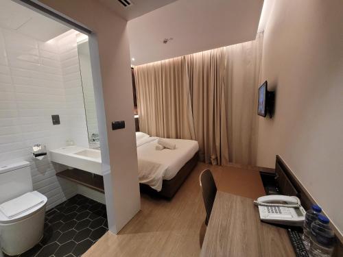 新加坡Wink Hotel @ Bugis的一间带床、水槽和卫生间的浴室
