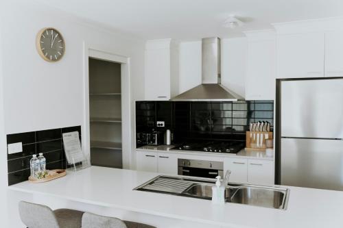 Golden SquareSpacious Stay On Shamrock, Bendigo的白色的厨房配有水槽和冰箱