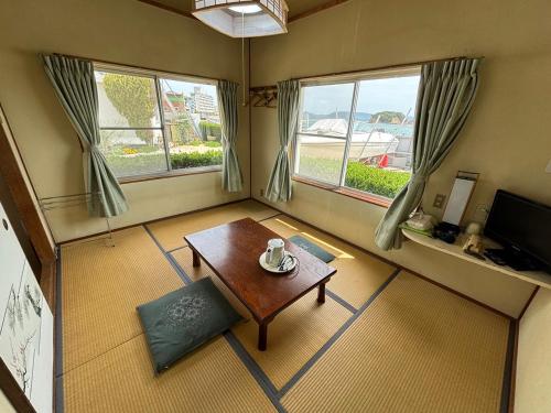 土庄町入舟旅馆的客厅配有桌子和2扇窗户